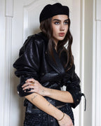 A black leather jacket with waist belt, textured