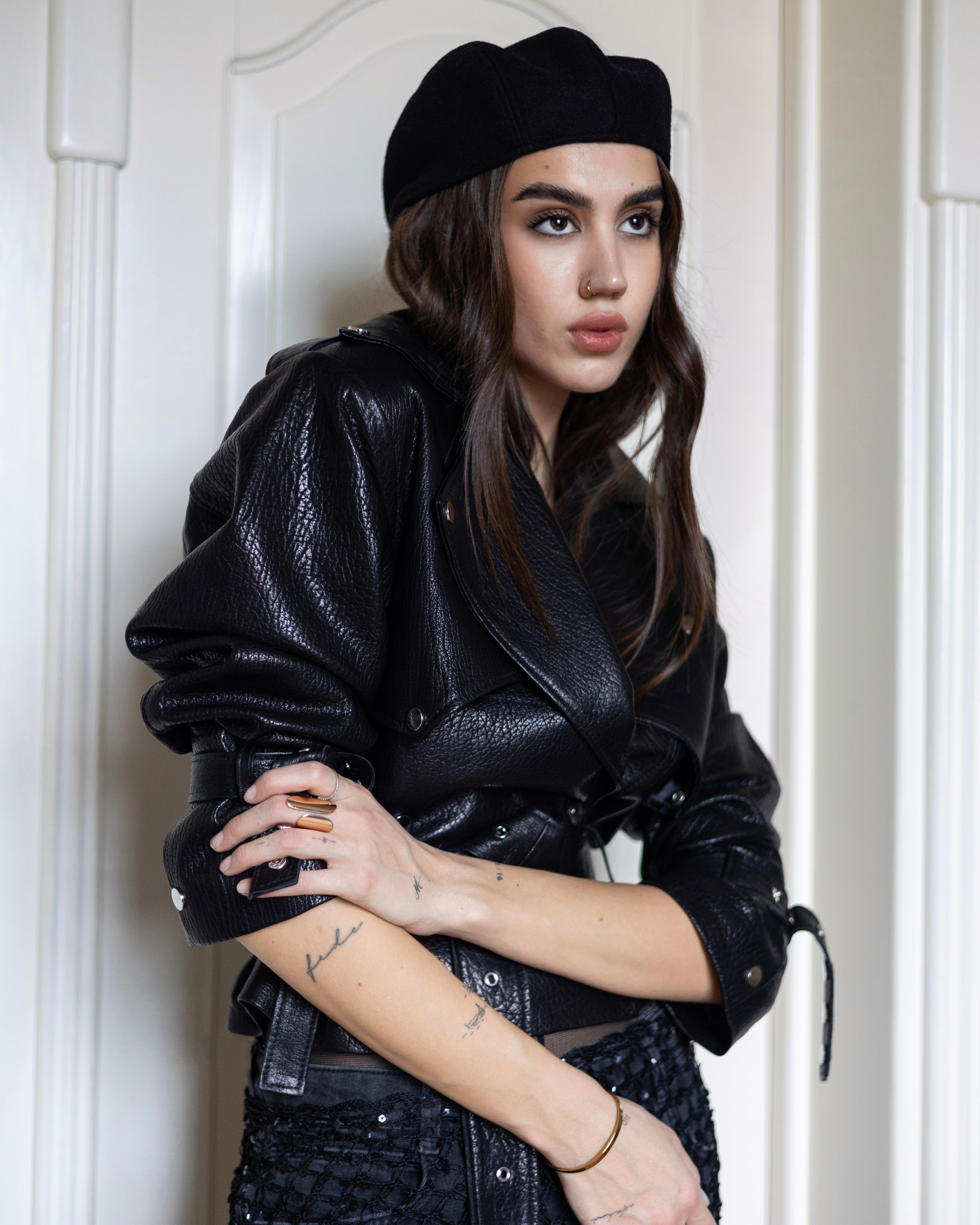 A black leather jacket with waist belt, textured